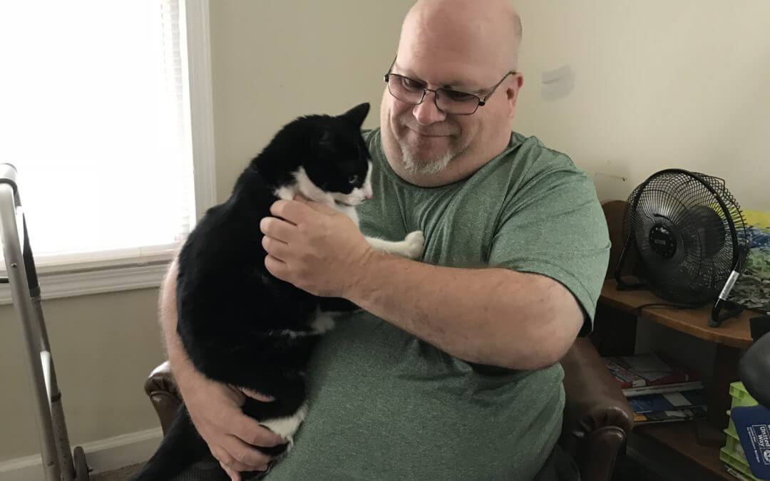 A military veteran holds a cat he adopted through the MHS for Military adoption program.