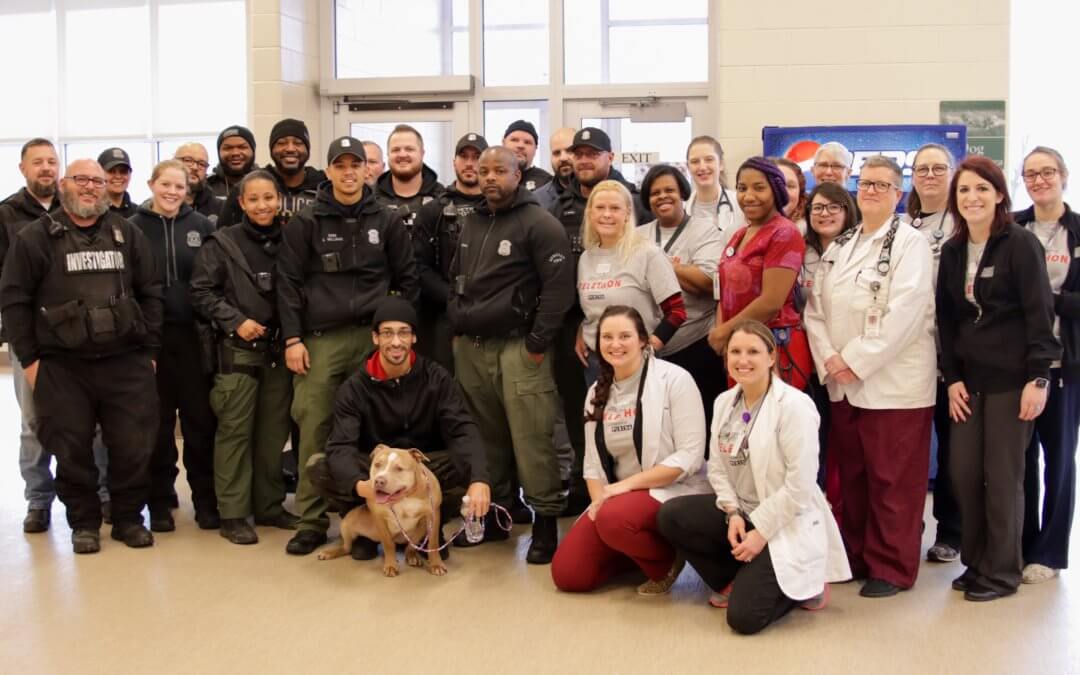MHS medical staff poses with dog and his owner, Detroit police.